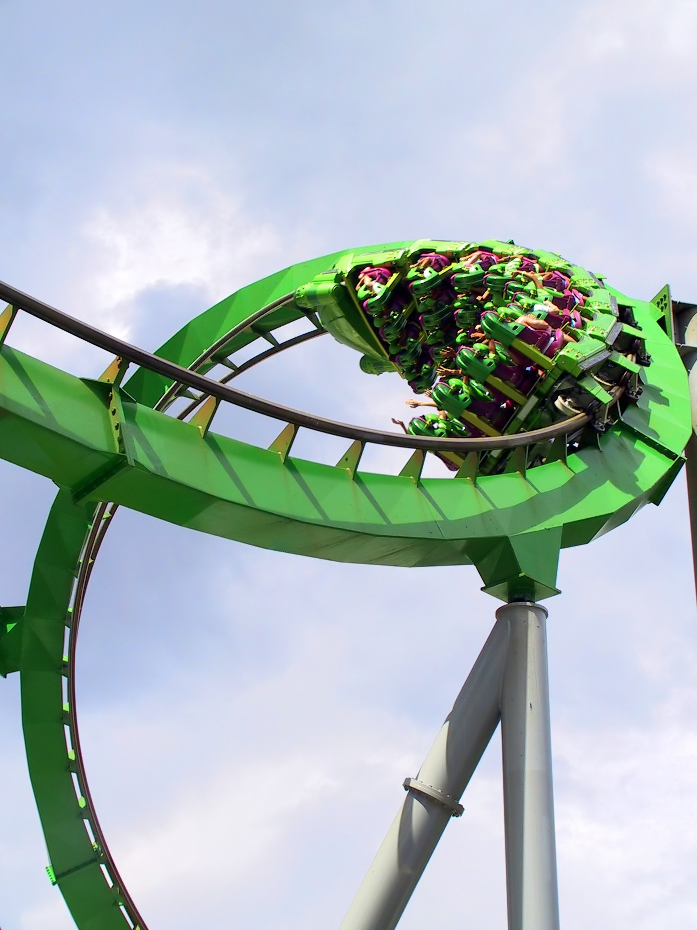 roller coaster with people on it going through a loop