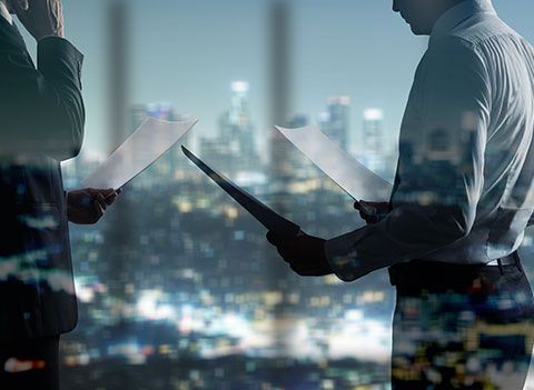 guy looking at paper with city skyline in the background